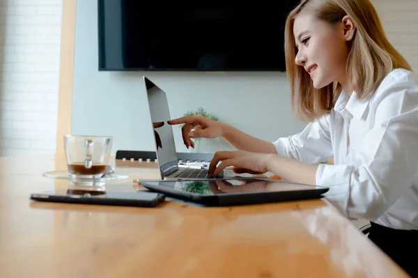 Ung affärskvinna arbetar med mobiltelefoner och bärbara datorer i — Stockfoto
