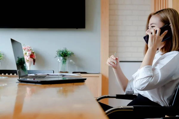 Young businesswoman work with mobile phones and notebooks in the — Stock Photo, Image