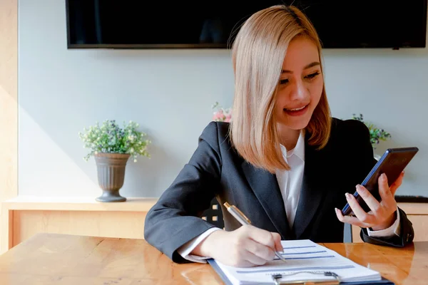 Ung kvinna sitter för kandidat på anställningsintervju och skriva r — Stockfoto