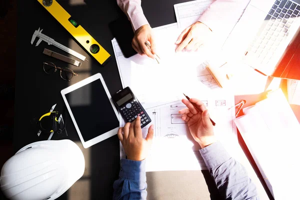 Engenheiros apontando para a construção em planta e usando laptop para — Fotografia de Stock