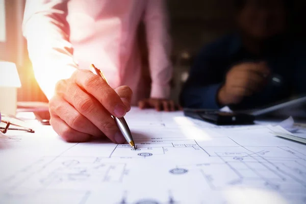 Engenheiros apontando para a construção em planta e usando laptop para — Fotografia de Stock