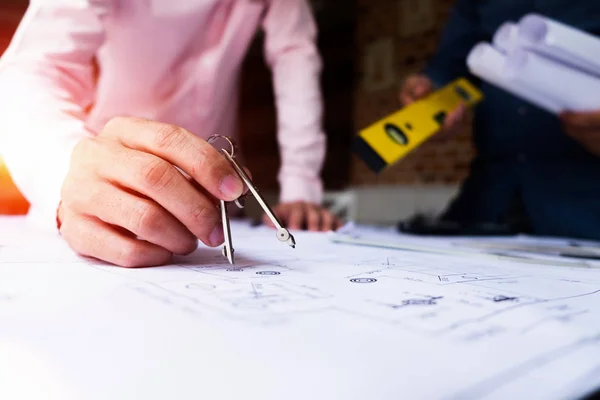 Engenheiros apontando para a construção em planta e usando laptop para — Fotografia de Stock