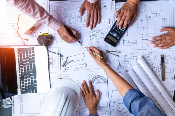 Engenheiros apontando para a construção em planta e usando laptop para — Fotografia de Stock