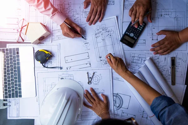 Engenheiros apontando para a construção em planta e usando laptop para — Fotografia de Stock