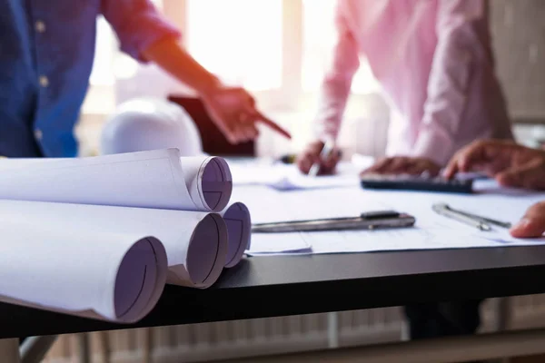 Engenheiros apontando para a construção em planta e usando laptop para — Fotografia de Stock