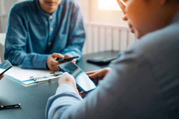 Jonge zakenmensen met smartphone op houten tafel delen dat — Stockfoto