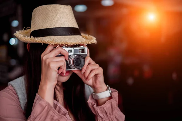 Smiling woman traveler with backpack holding vintage camera on h — Stock Photo, Image