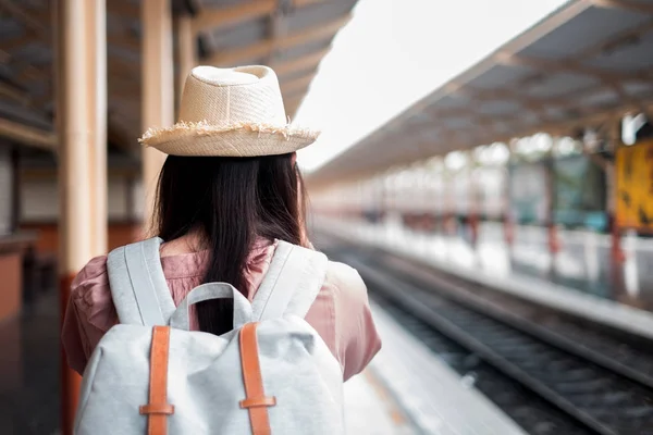 Mujer sonriente viajero con mochila sosteniendo la cámara vintage en h — Foto de Stock