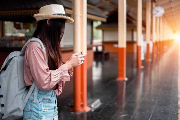 Mujer sonriente viajero con mochila sosteniendo la cámara vintage en h — Foto de Stock