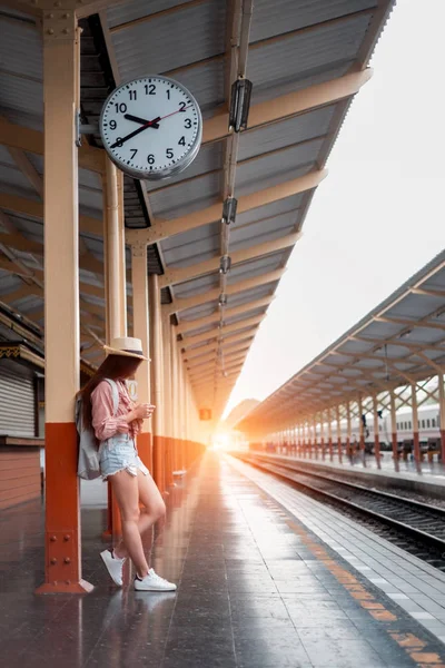 Mujer sonriente viajero con mochila sosteniendo la cámara vintage en h — Foto de Stock