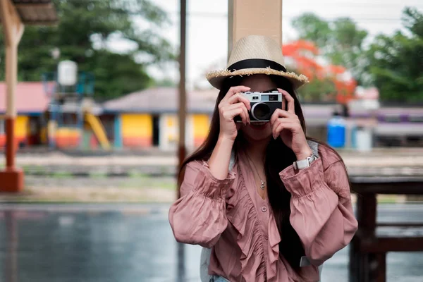 Lächelnde Reisende mit Rucksack, der eine alte Kamera in der Hand hält — Stockfoto