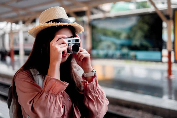 Smiling woman traveler with backpack holding vintage camera on h — Stock Photo, Image