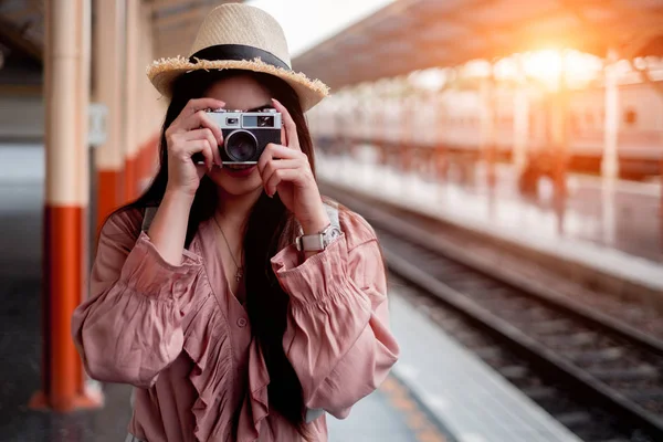 Lächelnde Reisende mit Rucksack, der eine alte Kamera in der Hand hält — Stockfoto