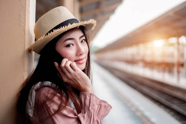이마에 스마트폰을 들고 여행하는 미소짓는 여자 — 스톡 사진