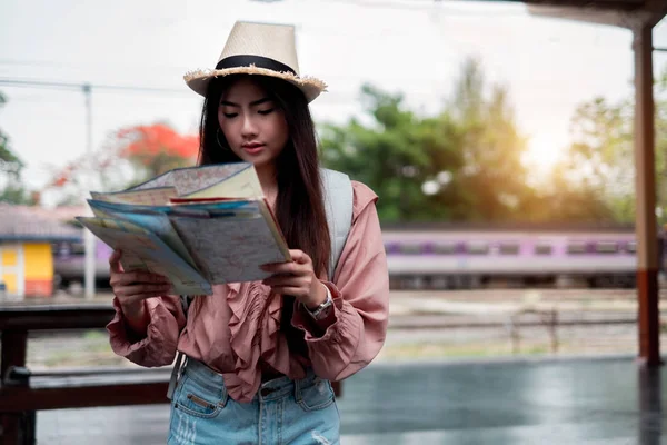 Viajero sonriente con mochila que sostiene la planificación del mapa del mundo — Foto de Stock