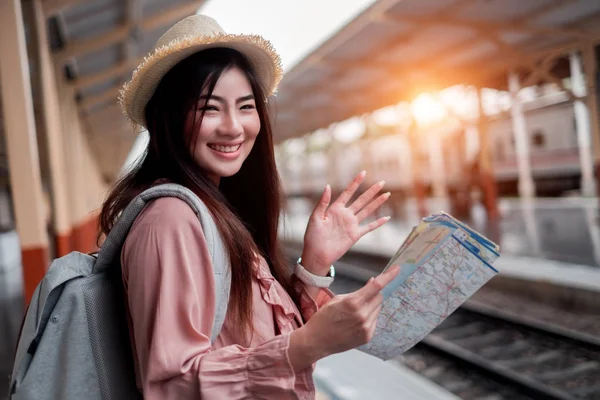 Viajero sonriente con mochila que sostiene la planificación del mapa del mundo — Foto de Stock