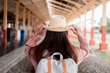 Tatil rela sırt çantası ile şapka tutan Gülümseyen kadın gezgin