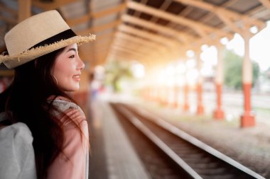 Gülümseyen kadın gezgin tatil rel sırt çantası ile sol aranıyor