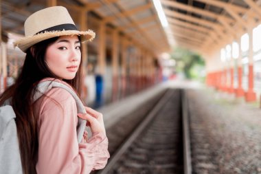 Tatil r sırt çantası ile kamera görünümlü Gülümseyen kadın gezgin