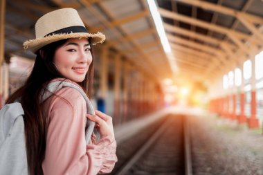 Tatil r sırt çantası ile kamera görünümlü Gülümseyen kadın gezgin