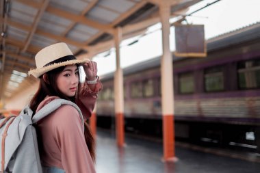 Tatil rela sırt çantası ile şapka tutan Gülümseyen kadın gezgin