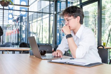 Mobil laptop ve belgeler ile çalışan genç işadamı