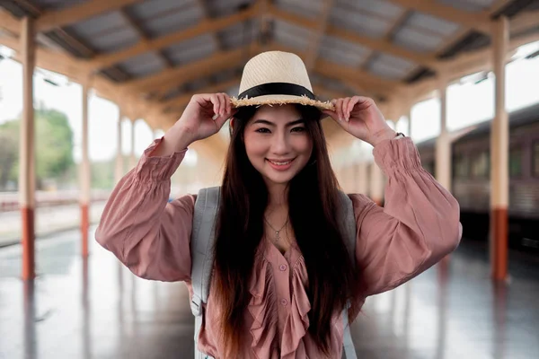 Femme souriante voyageur tenant chapeau avec sac à dos sur rela vacances — Photo