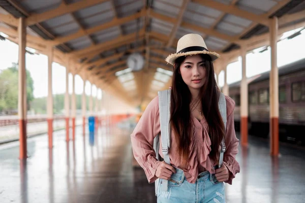 Femme souriante voyageur regardant appareil photo avec sac à dos en vacances r — Photo