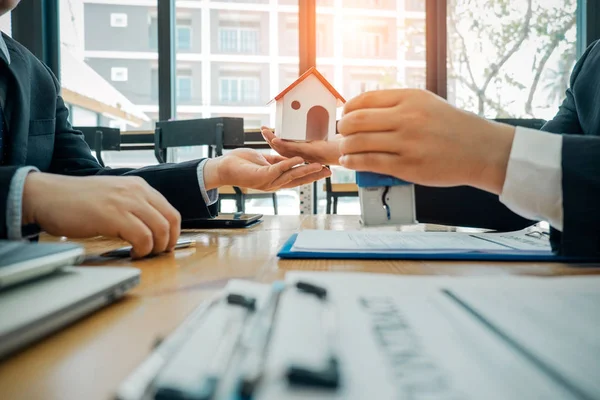 Fastighets mäklare som håller modell hus och automatisk stämpel för s — Stockfoto