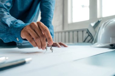 mühendisler plan üzerinde bina işaret ve dizüstü bilgisayar kullanarak 
