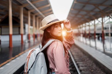 Gülümseyen kadın gezgin tatil rel sırt çantası ile sol aranıyor