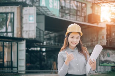 ofis dışında plan modern proje tutan helmat görünümlü kamera giyen genç mühendisler, Mühendis kavramı