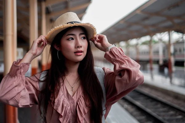 Femme souriante voyageur tenant chapeau avec sac à dos sur rela vacances — Photo