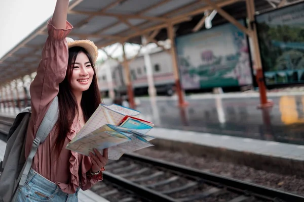 Viajero sonriente con mochila que sostiene la planificación del mapa del mundo — Foto de Stock