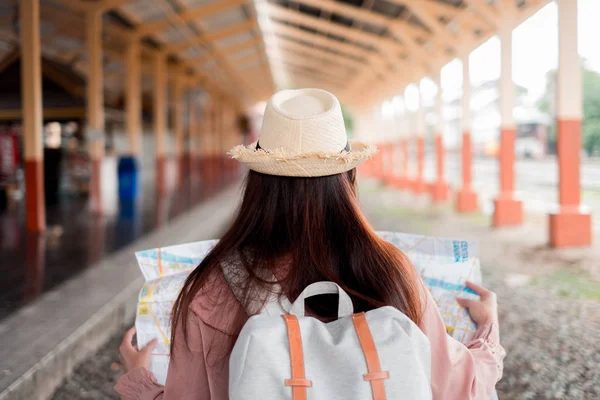 Viajero sonriente con mochila que sostiene la planificación del mapa del mundo — Foto de Stock