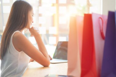 alışveriş çantaları, alışveriş concep ile alışveriş sitesi online zevk dizüstü bilgisayar kullanarak güzel kadın