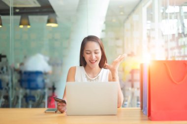 dizüstü bilgisayar kullanarak kredi kartı tutan güzel kadın shoping çanta web sitesi online, alışveriş concep ile alışveriş keyfini çıkarın