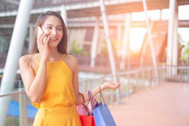 Alışveriş poşetleri ve akıllı telefon ile alışveriş merkezi, alışveriş kavramı açık havada duran alışveriş zevk ile güzel kadınlar