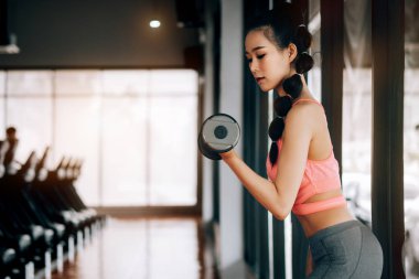 fitness spor kulübünde spor kadın dum ile silah için egzersiz yapıyor