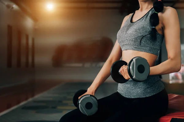 Sport woman at fitness gym club doing exercise for arms with dum — Stock Photo, Image