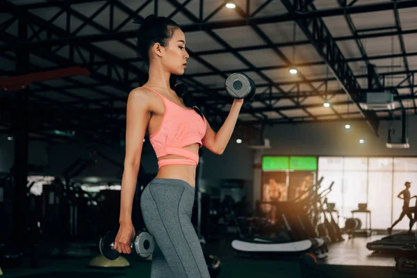fitness spor kulübünde spor kadın dum ile silah için egzersiz yapıyor