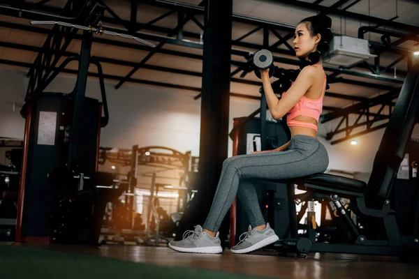 fitness spor kulübünde spor kadın dum ile silah için egzersiz yapıyor