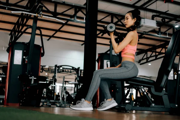 Deporte mujer en gimnasio gimnasio club haciendo ejercicio para los brazos con dum — Foto de Stock