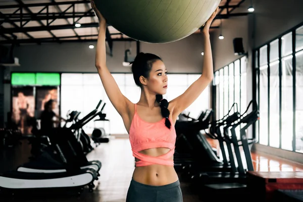 Deporte mujer en gimnasio gimnasio club haciendo ejercicio para los brazos con gimnasio — Foto de Stock