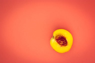 turuncu bir arka plan üzerinde olgun şeftali yarısı. metin için kopya alanı.