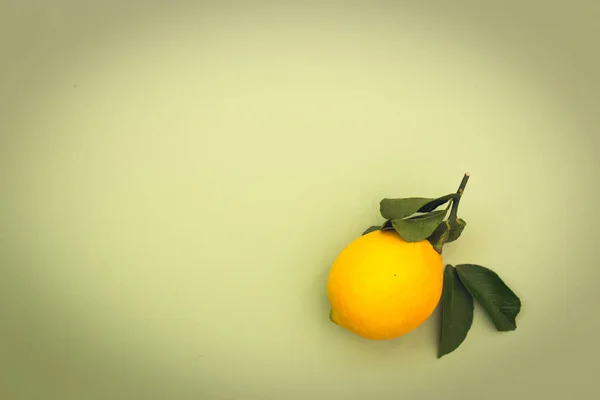 Yeşil arkaplanda yaprakları olan sarı limon, metin için kopyalama alanı