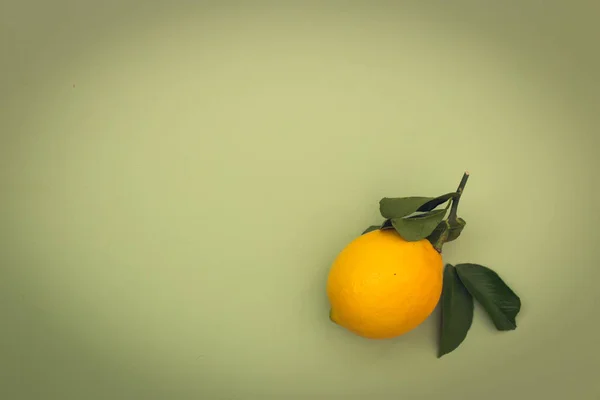 Yeşil arkaplanda yaprakları olan sarı limon, metin için kopyalama alanı