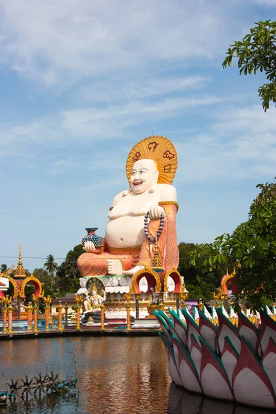 Statue of Laughing Buddha on blue sky background, bottom view , Buddhism, Thailand, Koh Samui. Statue of Laughing Buddha on blue sky background, bottom view , Buddhism, Thailand, Koh Samui