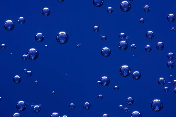 koyu mavi arka plan üzerinde içki gaz kabarcıkları. Doku. Yenileyici.