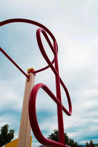 mavi gökyüzü arka plan üzerinde bir zincirler üzerinde kırmızı spor ekipmanları. çocuk oyun alanı.